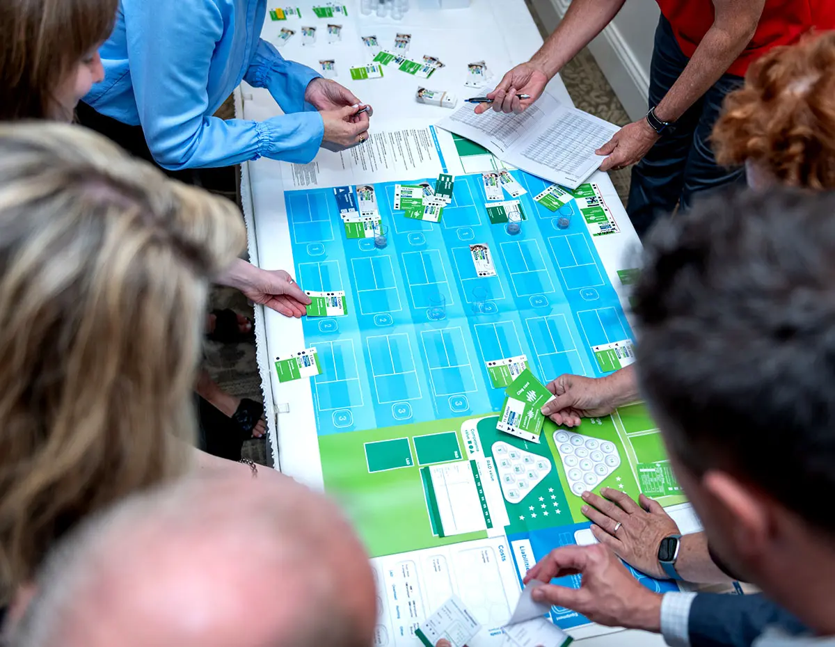 Top view of people playing CELEMI Tango™ business simulation