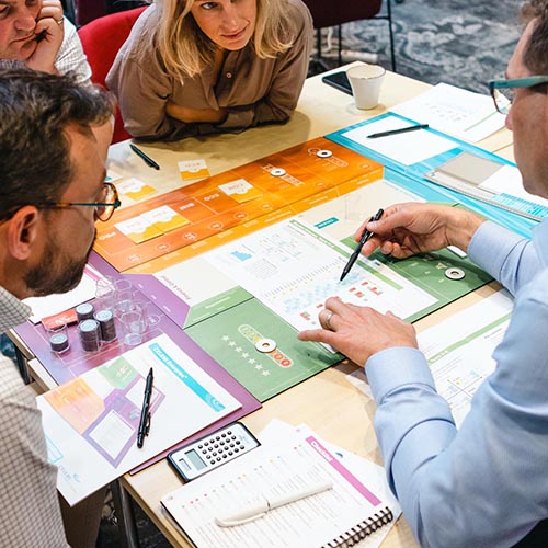 People in a room playing CELEMI Enterprise™ business simulation