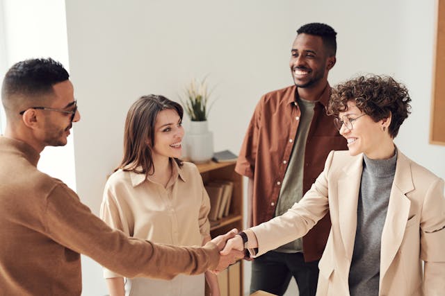 New staff members shake hands during an employee onboarding session.